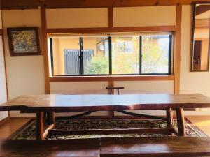 四万十市Shimanto River House Yuube-Tei的窗户客房内的大木桌