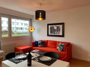 日内瓦Geneva Cosy的客厅配有红色的沙发和桌子