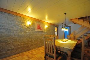 欣特察尔滕Ferienhaus Hinterzarten的一间设有木桌和砖墙的用餐室