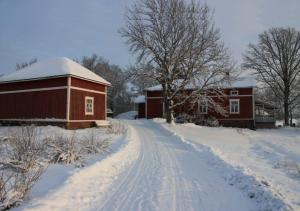 PerniöLeipyölin tila的红谷仓旁一条有雪覆盖的道路