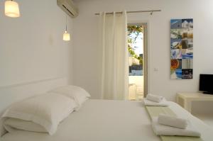 阿波罗尼亚Kapetan Tasos Suites的白色的卧室设有床和窗户