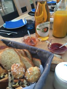 Ver-sur-MerLe mas Normand的一张桌子,上面放着一篮面包和一瓶橙汁