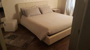 阿斯蒂Appartamento in centro storico的一张带白色床单和枕头的床