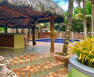 卡诺阿CanoaOasis的一个带稻草伞的游泳池的度假酒店