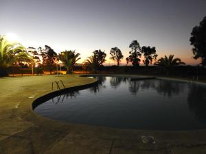 通戈伊Agradable Casa en Condominio Prados del Mar Tongoy的公园内的游泳池,背景是日落
