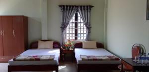 Châu Làng Chánh海当酒店的客房设有两张床和窗户。