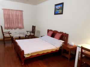 锡朗米妮旅馆的一间卧室配有一张床和两把椅子