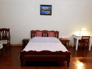 锡朗米妮旅馆的卧室配有一张床和一张桌子及椅子