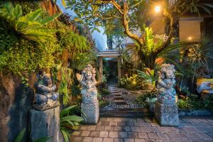 登巴萨格里亚屯井纱丽旅馆的一条小径中间的带雕像的花园