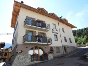 科姆梅扎杜拉Aparthotel Dolomites Living&Relax的一座带阳台的建筑,鲜花盛开