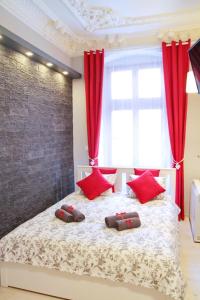弗罗茨瓦夫Grey Rooms的一间卧室配有一张带红色窗帘的大床