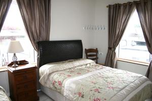基尔肯尼Celtic House B&B的一间卧室配有一张床、一个梳妆台和一扇窗户。