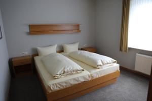 奥尔斯贝格Ferienhaus zur Sonne的一间卧室配有带两个枕头的床和窗户