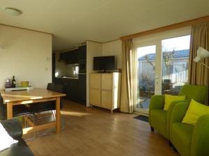 比伦Chalet Seazon R23的客厅配有绿色沙发和桌子