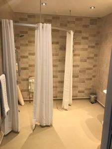 大雅茅斯The Troll Cart Wetherspoon的带淋浴和白色窗帘的浴室