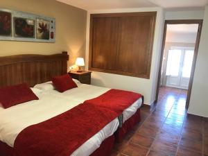 韦斯卡尔Hotel Patri的一间卧室配有一张带红色毯子的大床