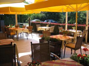 布达佩斯莫尔纳酒店的一间带桌椅和黄色遮阳伞的餐厅