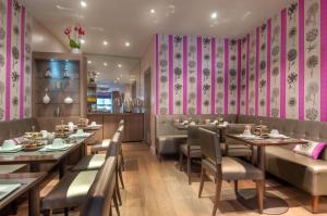 巴黎马森纳酒店的餐厅设有桌椅和粉红色的墙壁