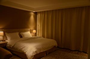哈伊勒منازل الشمال للشقق المخدومة Manazel Al Shamal Serviced Apartments的一间卧室配有一张带白色床单的大床