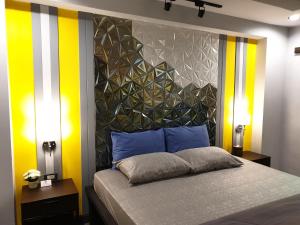 大城班百脉精品酒店 的一间卧室配有一张黄色和白色条纹的床