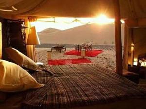 Foum ZguidMaroc Sahara Luxury Camp & Tours的海滩前的卧室