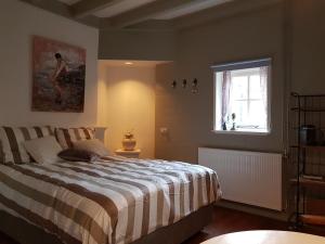 欣德洛彭Atelier B&B 'Sinnestriel'的一间卧室设有一张大床和一个窗户。
