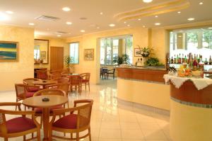 里米尼德拉普拉格酒店的一间带桌椅的餐厅和一间酒吧