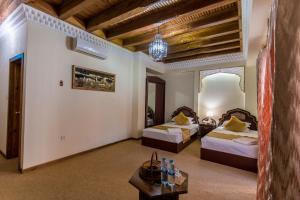 布哈拉库卡尔多什精品酒店 的酒店客房设有两张床和一张桌子。