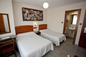 蓬费拉达Hostal San Miguel的酒店客房设有两张床和盥洗盆