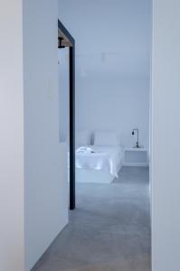 阿达玛斯L’arco Milos Suite的白色的客房配有镜子和床