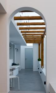阿达玛斯L’arco Milos Suite的通往走廊的拱门,走廊上设有白色的墙壁和木制天花板