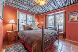 陶斯阿都比派恩斯住宿加早餐旅馆的一间卧室拥有橙色的墙壁和一张床及窗户
