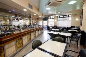 蓬费拉达Hostal San Miguel的一间带桌椅的餐厅和一间酒吧