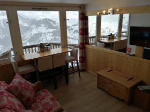 艾姆拉普拉涅Plagne AIME 2000 Ski Apartments的客厅配有桌子,享有山景