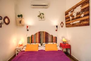 罗马Urban Chic Studio - by BRAVE的一间卧室配有一张带两个橙色枕头的紫色床