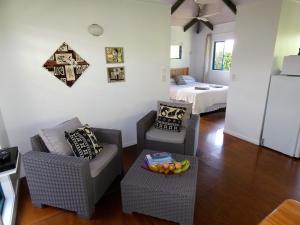 拉罗汤加Aroa Kainga Bungalows and Apartment的客厅配有两把椅子和一张床