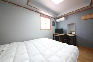 庆州Gyeongju Bee House的一间卧室配有一张床、一张书桌和一面镜子