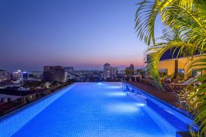 万象Lao Poet Hotel的一座游泳池,在晚上在一座建筑的顶部