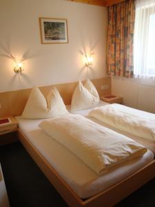萨尔巴赫Haus Zirmblick的一间卧室配有两张带白色床单和枕头的床。