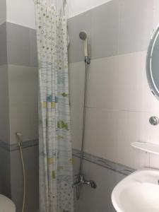 胡志明市VY庆旅馆 的浴室配有淋浴帘和盥洗盆。