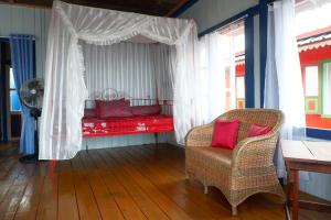 TanjungbingaRock and Wreck Dive Resort的客房配有一张带椅子的床和风扇
