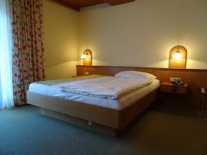 因斯布鲁克弗里德尔膳食旅馆的一间卧室配有一张带两个灯的床铺