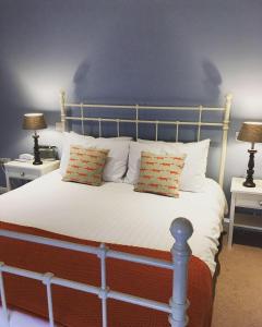 斯内蒂瑟姆The Rose & Crown, Snettisham的一间卧室配有一张带枕头的床和两盏灯。