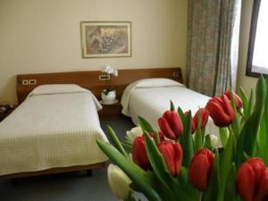 普拉塔蒂柏代诺莫妮卡别墅酒店的一间卧室配有两张红色和白色郁金香床。