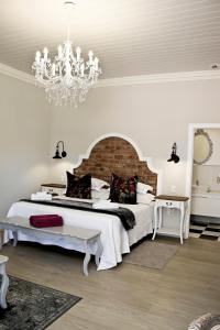 博福特西French Karoo Guesthouse的白色卧室配有一张大床和吊灯