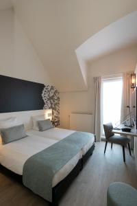 布鲁日布鲁日马丁斯酒店的一间卧室配有一张床、一张书桌和一个窗户。