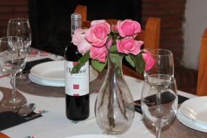 卡皮雷拉Apartamentos Rurales Rosendo: El Orégano的一瓶葡萄酒和花瓶中的花朵