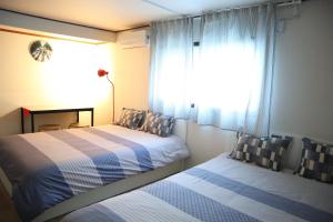 首尔郑家旅馆的一间卧室设有两张床和窗户。