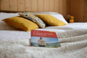 图恩诺Casa vacanze Dos de Loré - Relax a due passi da Tovel的坐在床上的书