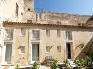 锡拉库扎Residence Ortigia的一座古老的石头建筑,拥有窗户和植物